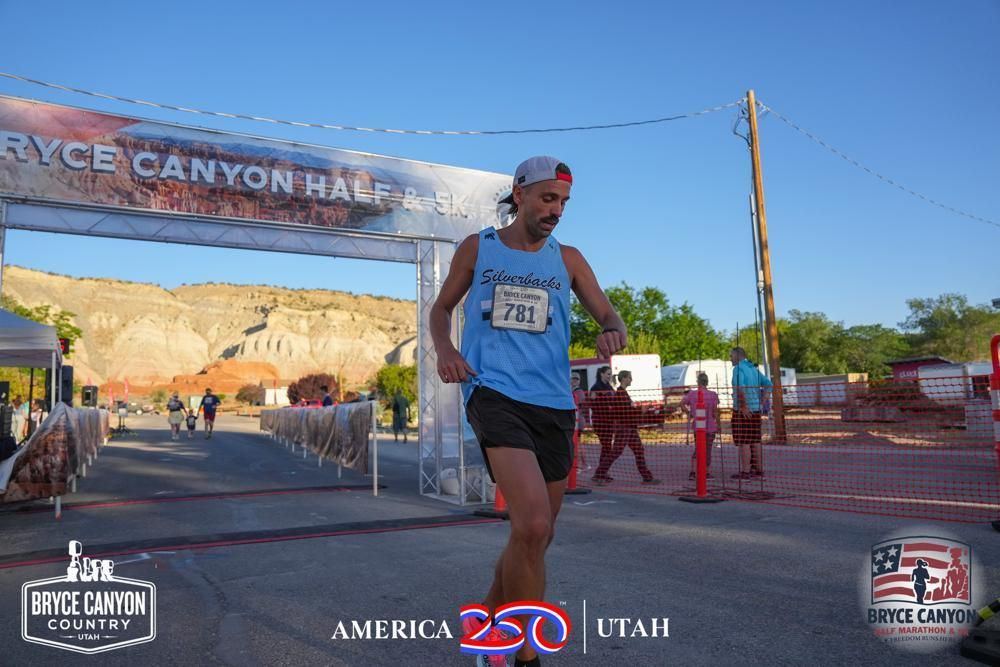 Finishing under the Bryce Canyon Half & 5K arch, Silverbacks singlet, bib 781.